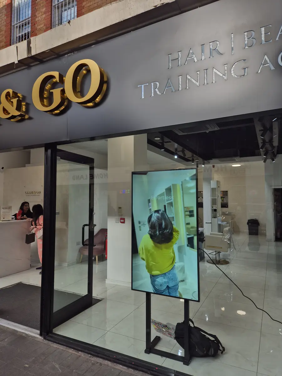 Digital signage screen in a UK beauty salon showcasing treatments.