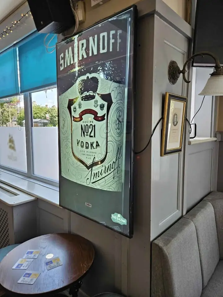 Digital display in a UK pub showing evening events and offers.