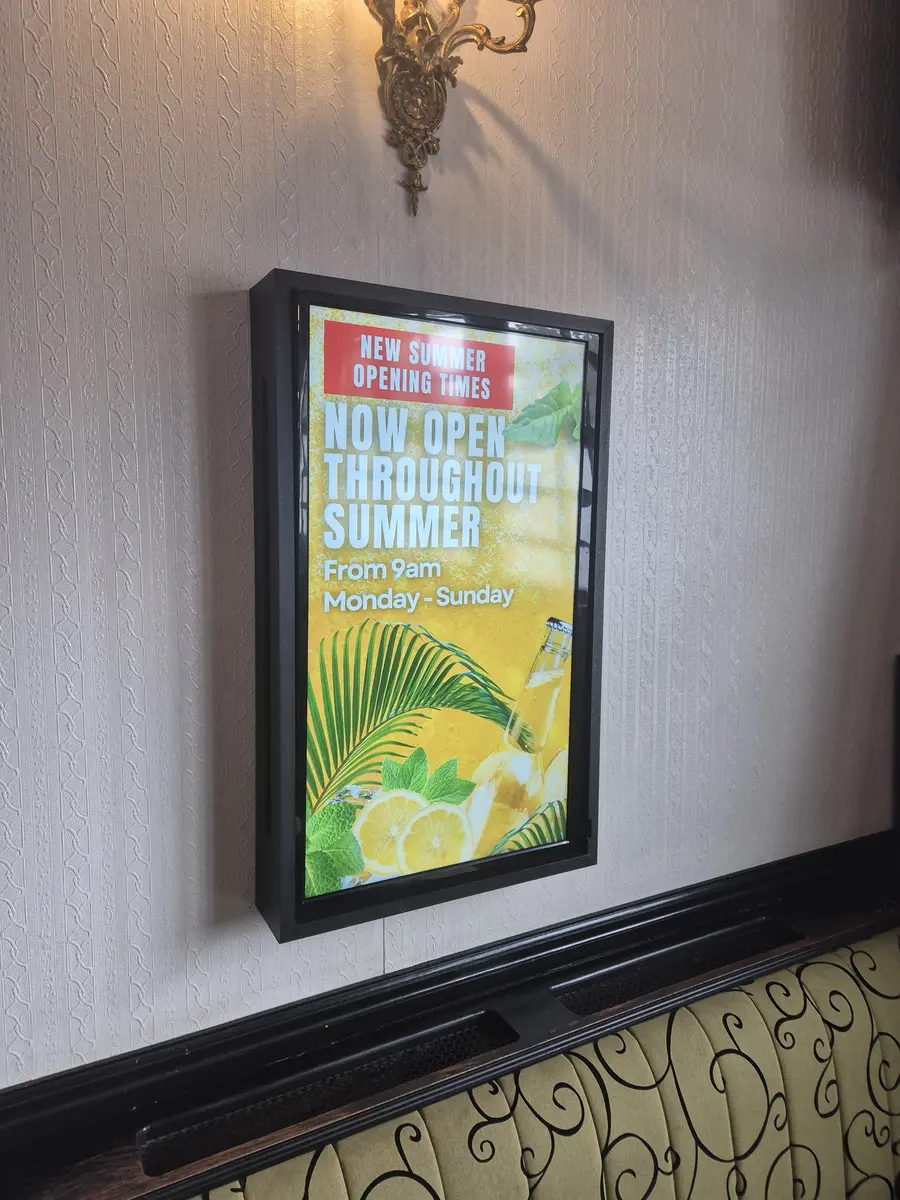 Digital screen in a UK bar showing food and drinks specials.